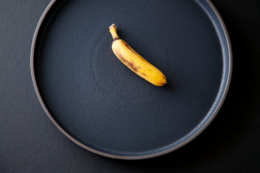 yellow banana peel on black round plate